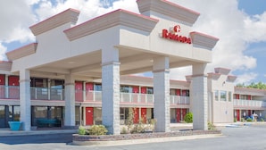 A Ramada hotel with a two-story structure, multiple balconies, and a parking lot. - Ramada Hotel & Conference Center by Wyndham Edgewood (Edgewood)