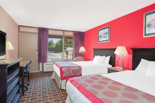 A hotel room with two beds, a desk, and a chair. - Ramada Hotel & Conference Center by Wyndham Edgewood (Edgewood)