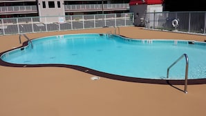 A rectangular swimming pool with a black edge and metal handrails. - Ramada Hotel & Conference Center by Wyndham Edgewood (Edgewood)