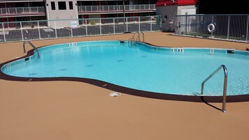 Una piscina al aire libre de temporada, sombrillas