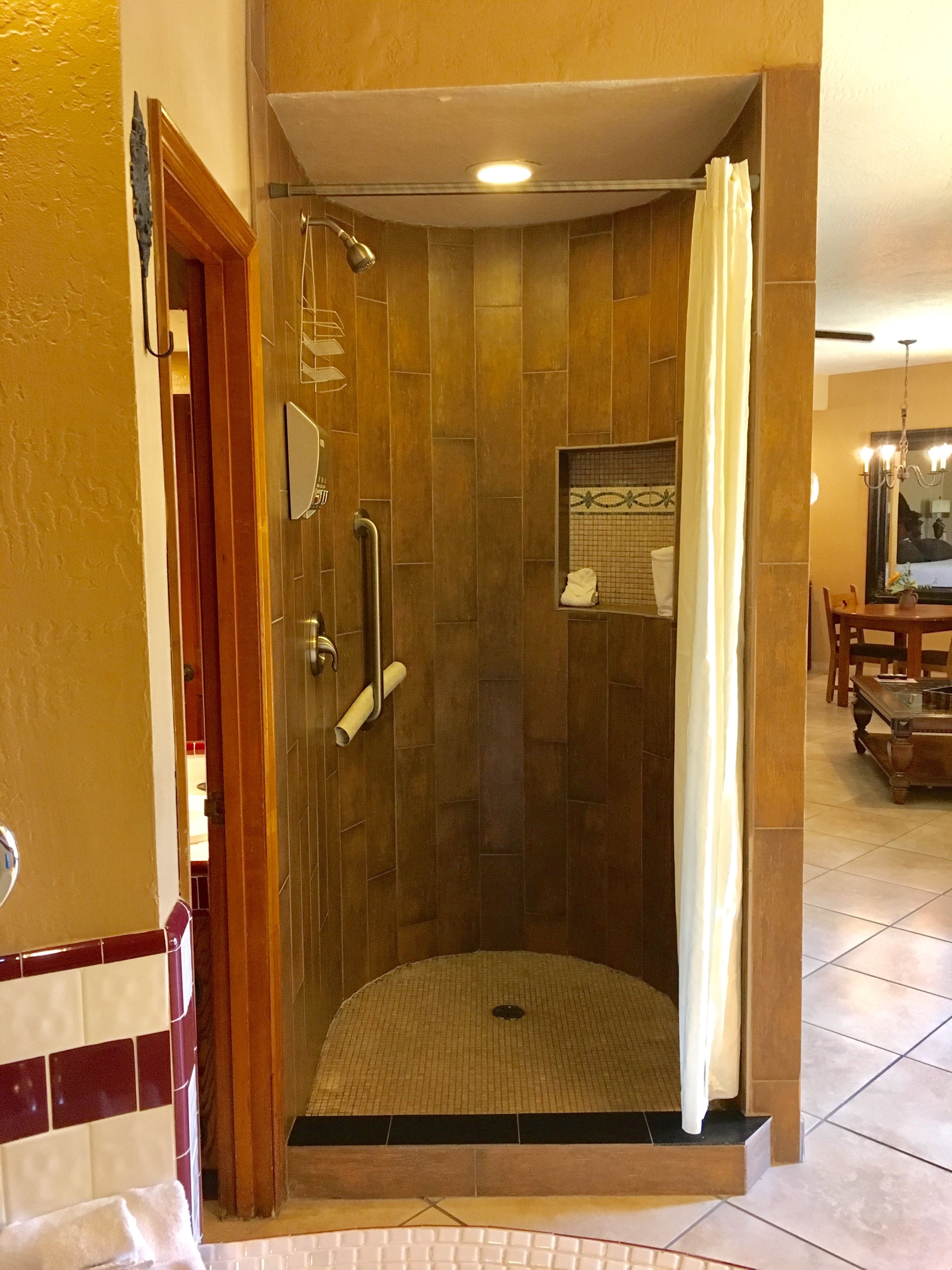 A walk-in shower with a glass door, a towel rack, and a showerhead.
