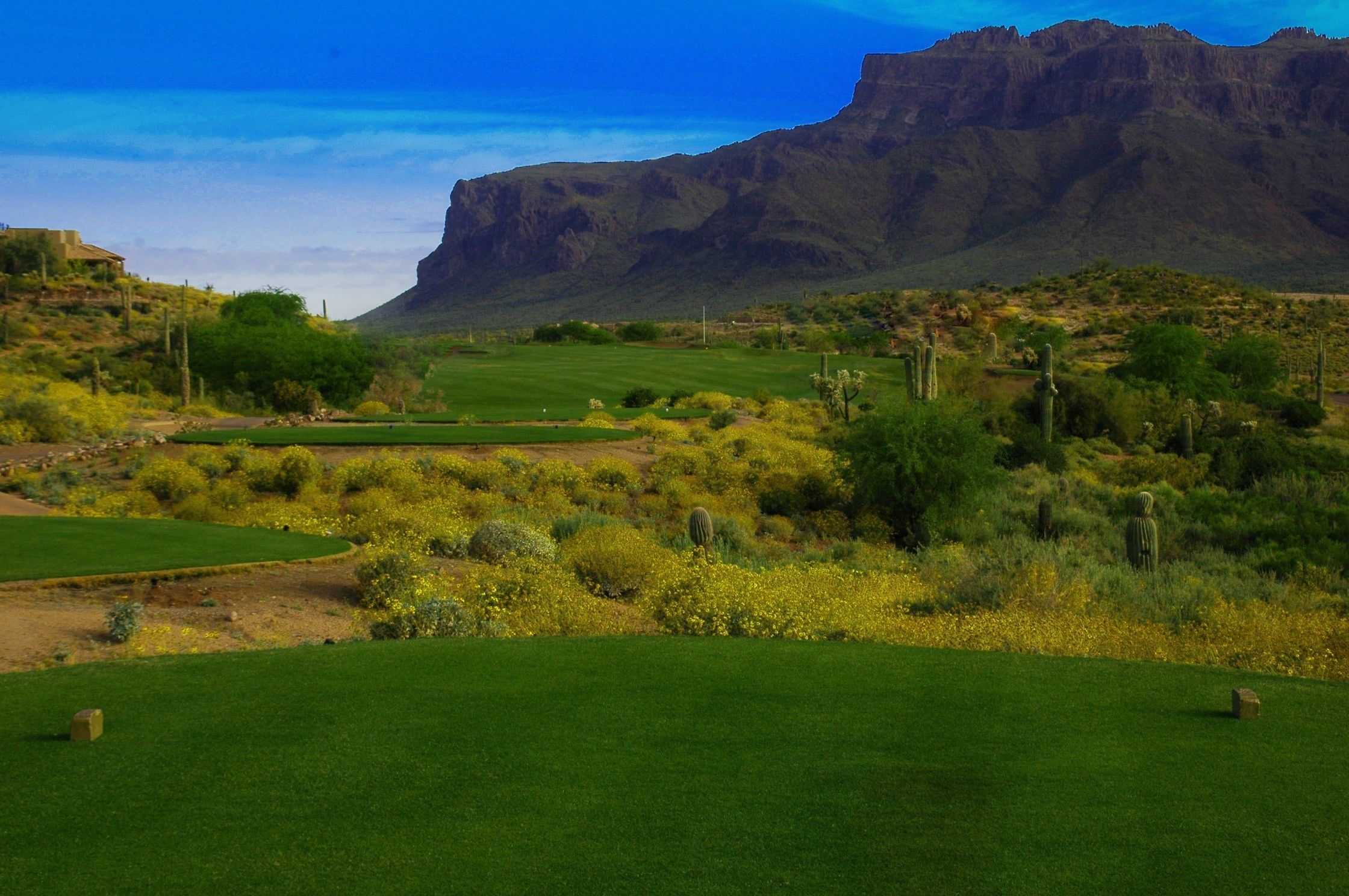 A golf course with a mountainous backdrop.