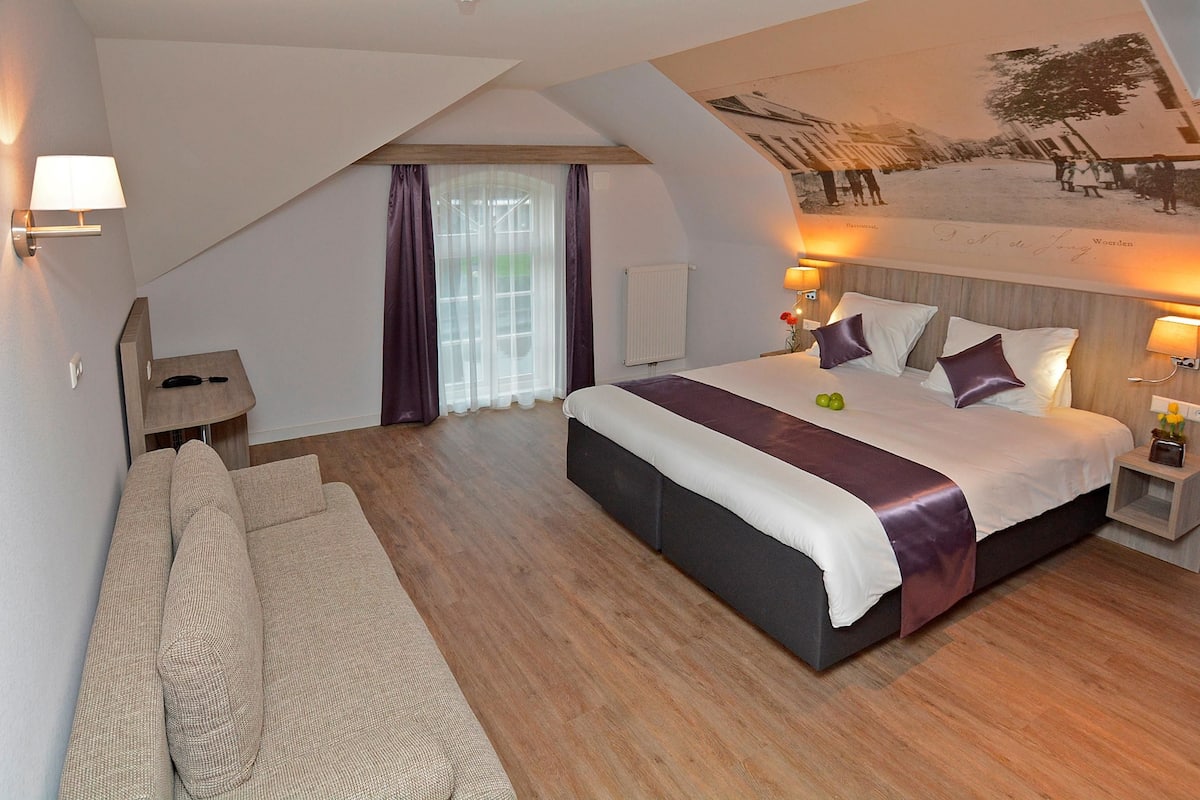 Une chambre d’hôtel moderne avec un grand lit, un canapé et une table à manger.