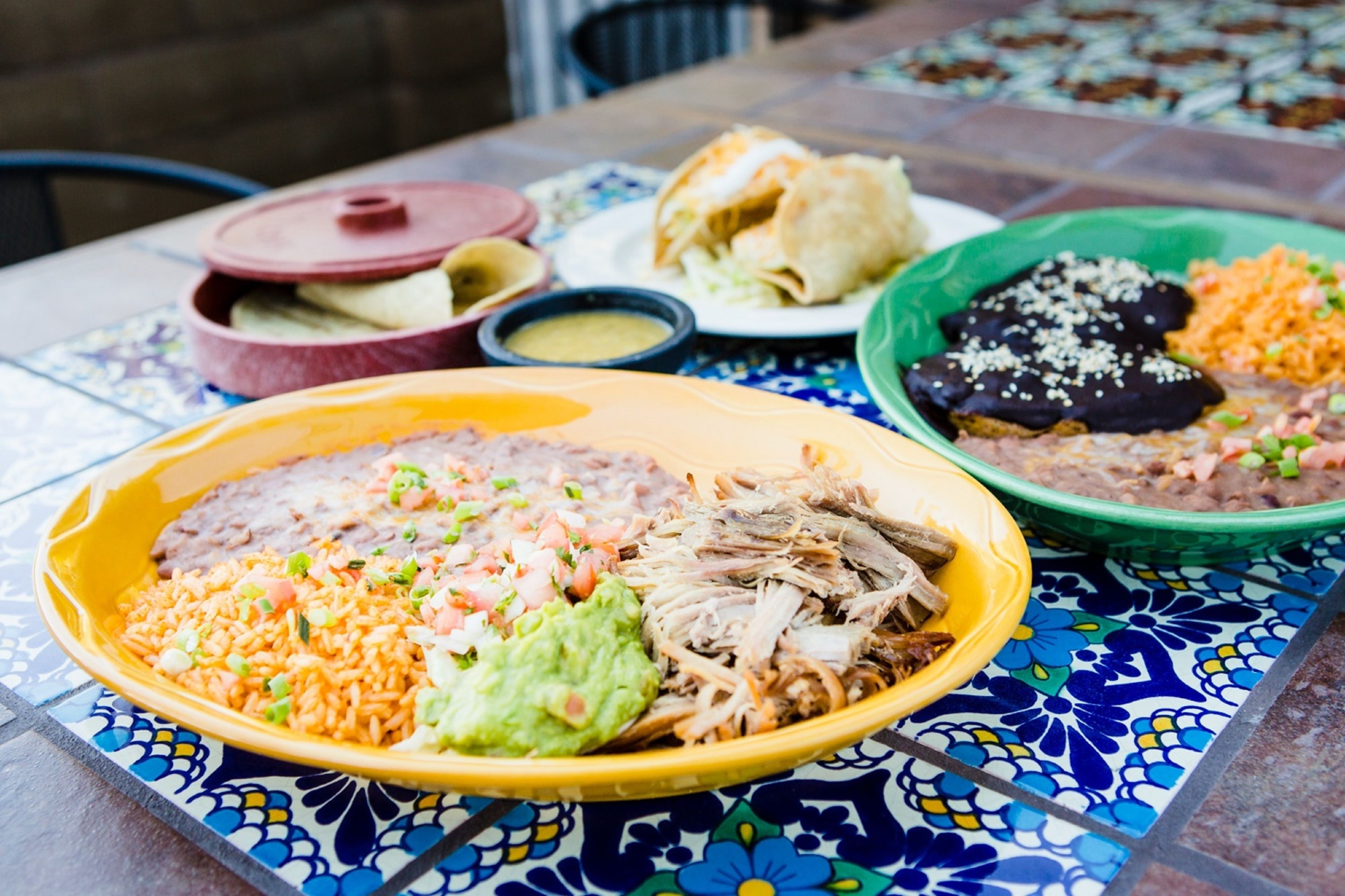 Una mesa con diversos platos, como arroz, frijoles y tortillas.