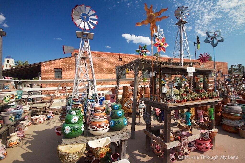 Un puesto de mercado con diversos artículos de cerámica y pinwheels.