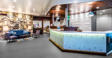 A modern reception area with a stone wall, a blue sofa, and a reception desk.