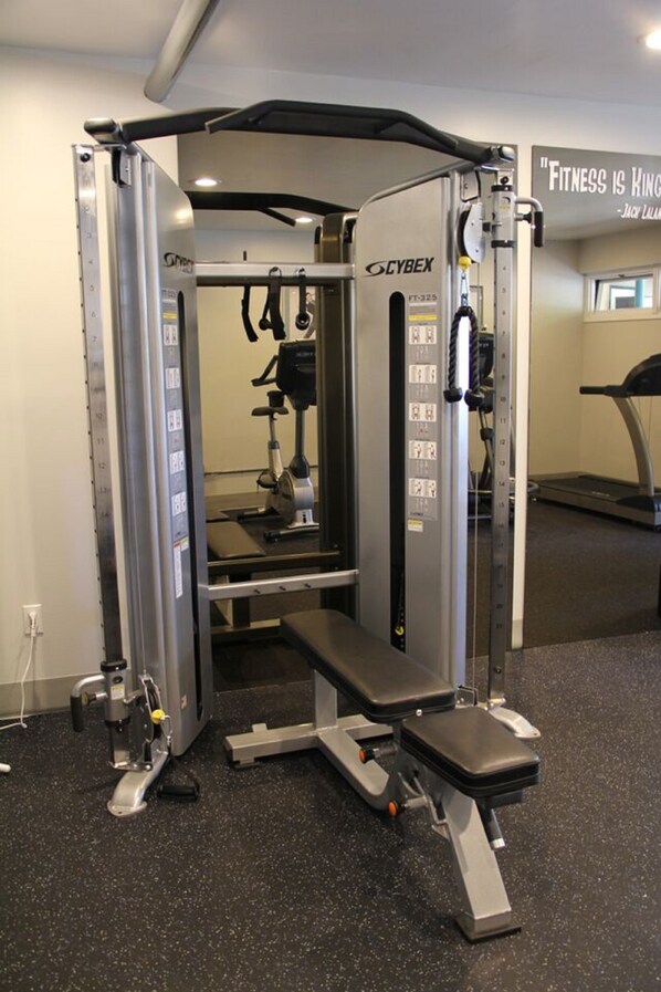 Un gimnasio Cybex con una prensa de banca y una estructura para sentadillas.