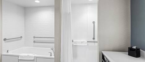 A modern bathroom with a bathtub, shower, and vanity.