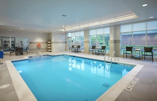 Una piscina techada, sillones reclinables de piscina