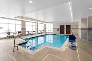 Una piscina techada, sillones reclinables de piscina