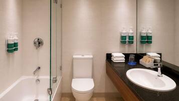 A modern bathroom with a glass-enclosed shower, a toilet, and a sink with a vanity.