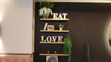 Une pièce avec un mur noir, des étagères en bois et un ventilateur.