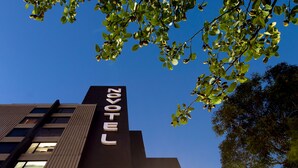 A modern hotel building with a prominent 'NOVOMATE' sign. - Novotel Sydney International Airport Hotel (Wolli Creek)