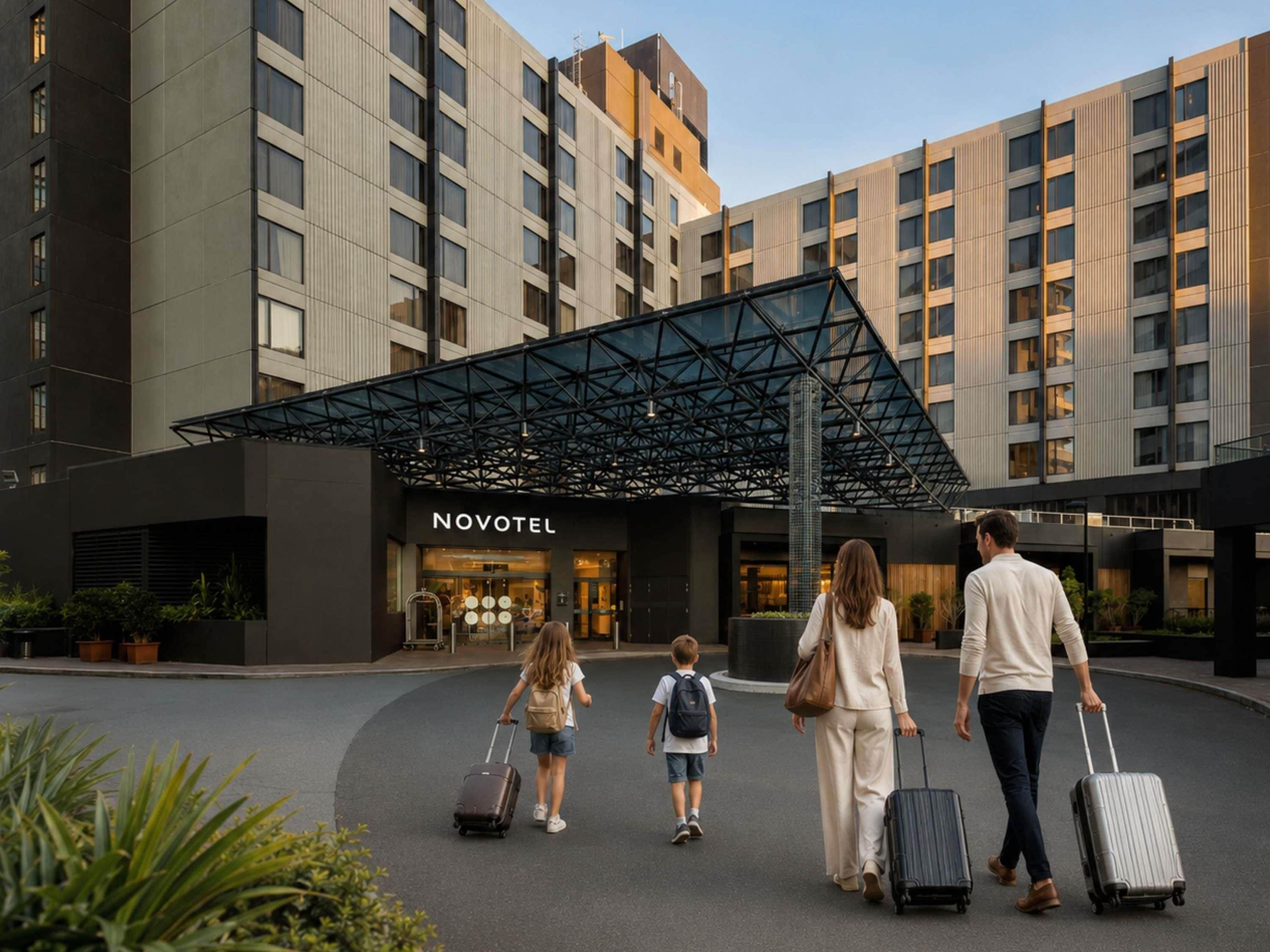 Entrada de hotel con diseño moderno, un letrero de Novotel y una marquesina.