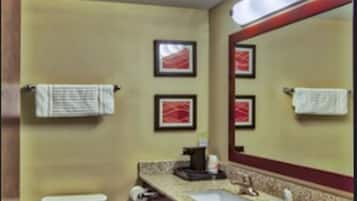 Un baño pequeño con inodoro, lavamanos y espejo.