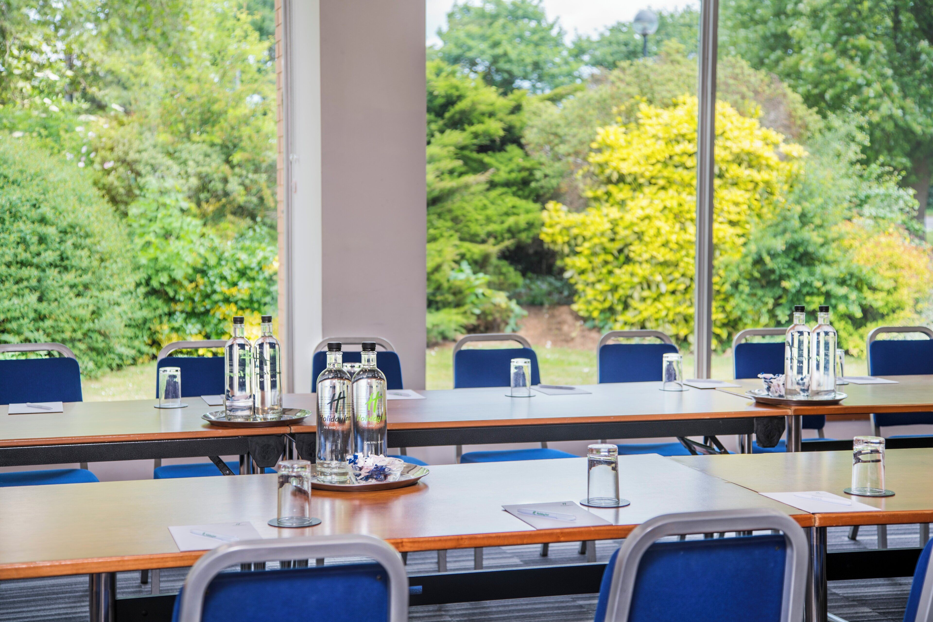 Une salle de conférence équipée de tables, de chaises et de verres.