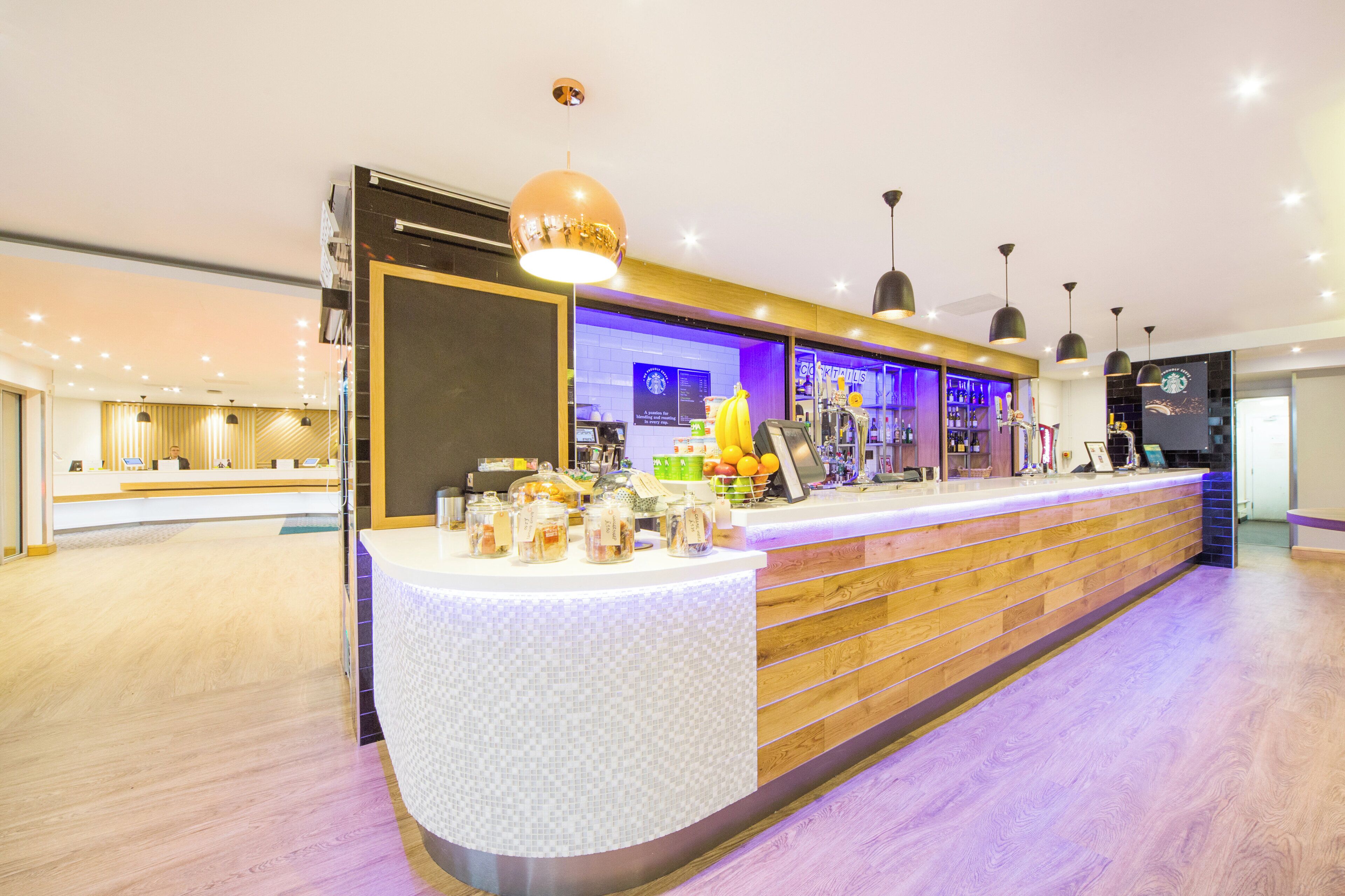 Una moderna zona de recepción con mostrador, estación de café y barra.