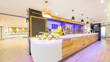 Una moderna zona de recepción con mostrador, estación de café y barra.