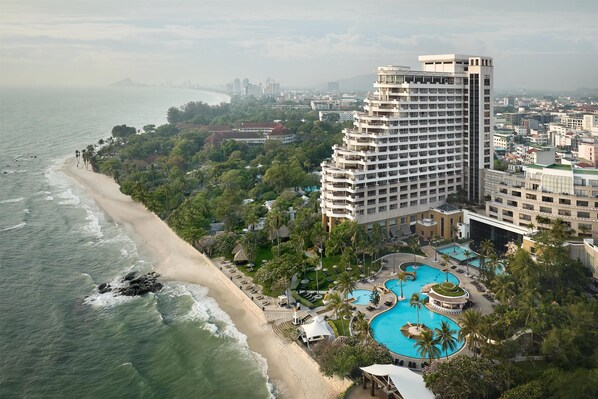 A high-rise hotel with a beachfront pool and ocean view.