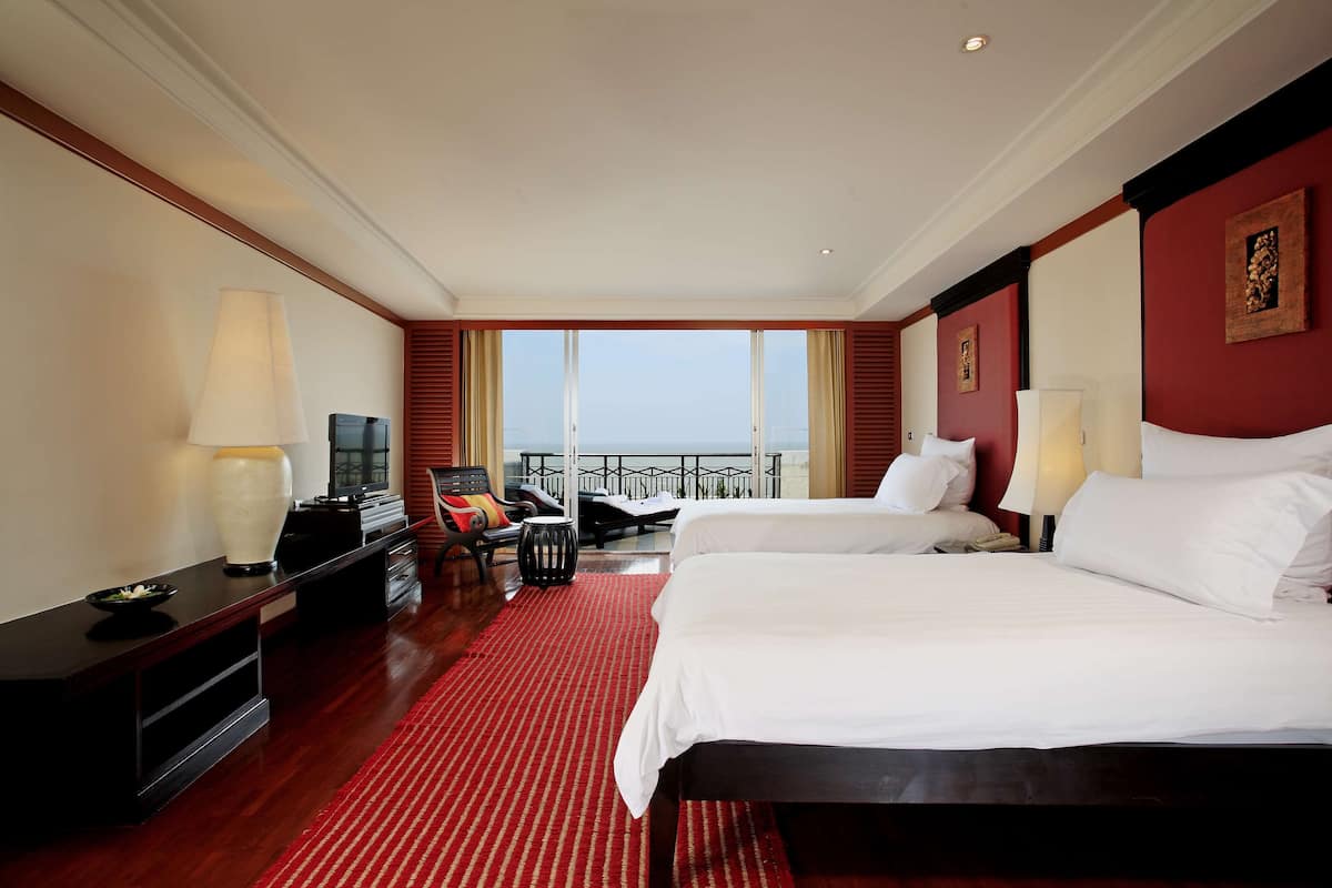 Een hotelkamer met twee bedden, een televisie, een bureau en een balkon met uitzicht.