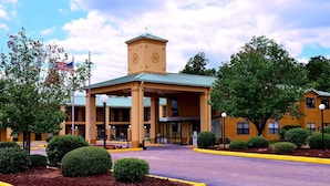 A hotel with a central tower, covered entrance, and landscaped surroundings. - Executive Inn Opp (Opp)