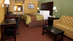 A hotel room with a bed, desk, chair, and sofa. - Executive Inn Opp (Opp)