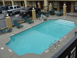 Zona de piscina con sillones de descanso y un cartel que indica una profundidad de 1,5 metros.