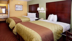 A hotel room with two beds, a bathroom, and a nightstand with a lamp. - Executive Inn Opp (Opp)