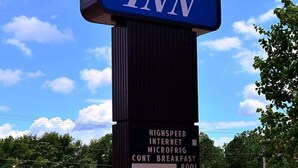 A sign for Executive Inn with amenities including high-speed internet, microfridge, continental breakfast, and a pool. - Executive Inn Opp (Opp)