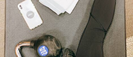 Une chambre d’hôtel avec un lit, un oreiller, une télécommande, un téléphone et un petit sac.
