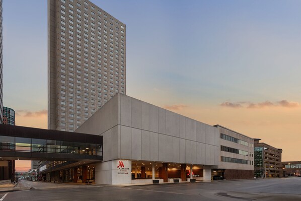Experience the sleek entrance of this urban hotel, featuring a large illuminated sign and modern architecture.