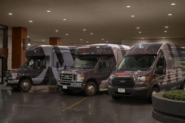 Three RVs parked in a well-lit indoor parking area with a modern design.