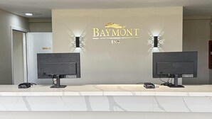 A reception desk with two monitors, a Baymont Inn logo, and an 'Employee Only' sign.