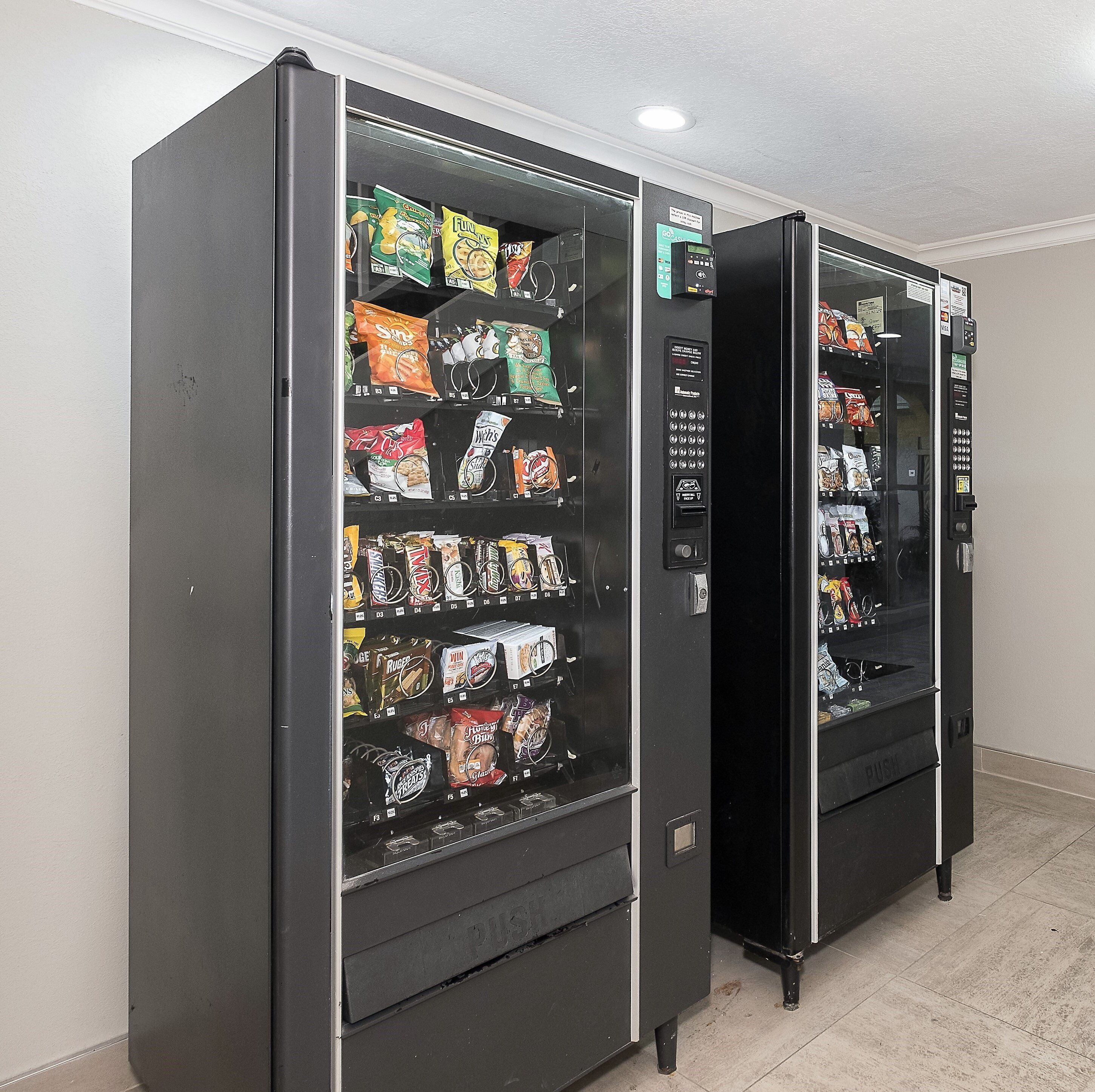 Two vending machines stocked with snacks and beverages.