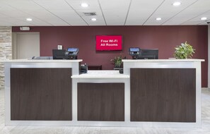 A reception desk with a sign indicating free Wi-Fi availability in all rooms.