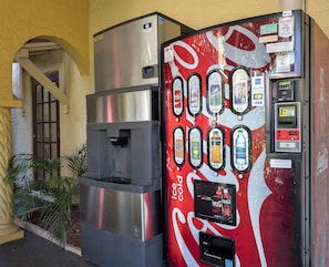A Coca-Cola vending machine with a water dispenser and a digital payment terminal. - Red Roof Inn Tampa Bay - St Petersburg (St. Petersburg)