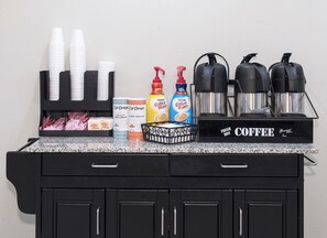 A coffee station with disposable cups, coffee makers, and condiments. - Red Roof Inn Tampa Bay - St Petersburg (St. Petersburg)