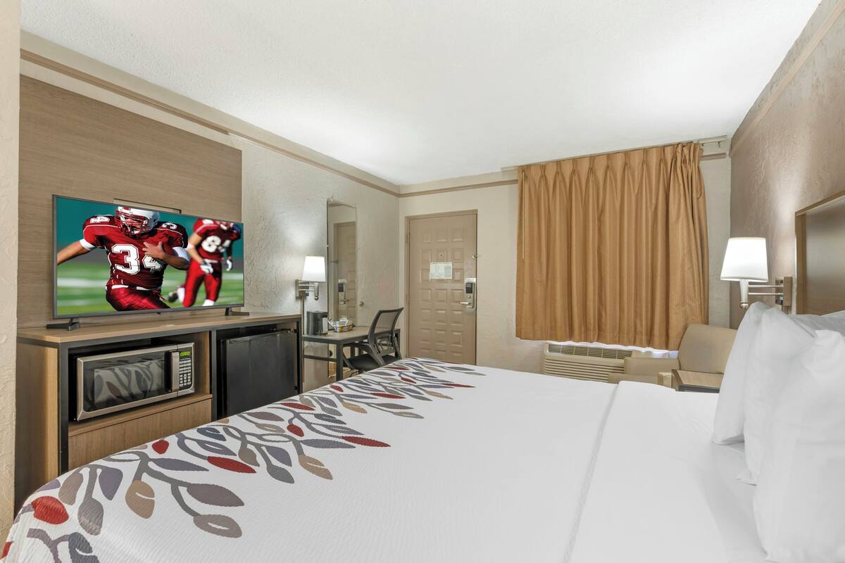 Une chambre d’hôtel équipée d’un lit, d’une télévision, d’un bureau et d’une chaise.