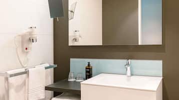 Une salle de bain moderne avec un lavabo blanc, un sèche-cheveux, un miroir et un porte-serviettes.