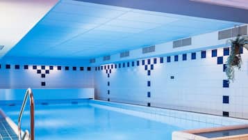 Una piscina techada, sillones reclinables de piscina