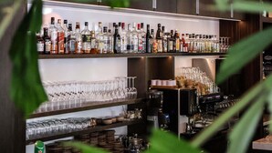 Eine Bar mit Regalen voller Spirituosenflaschen und Gläsern.