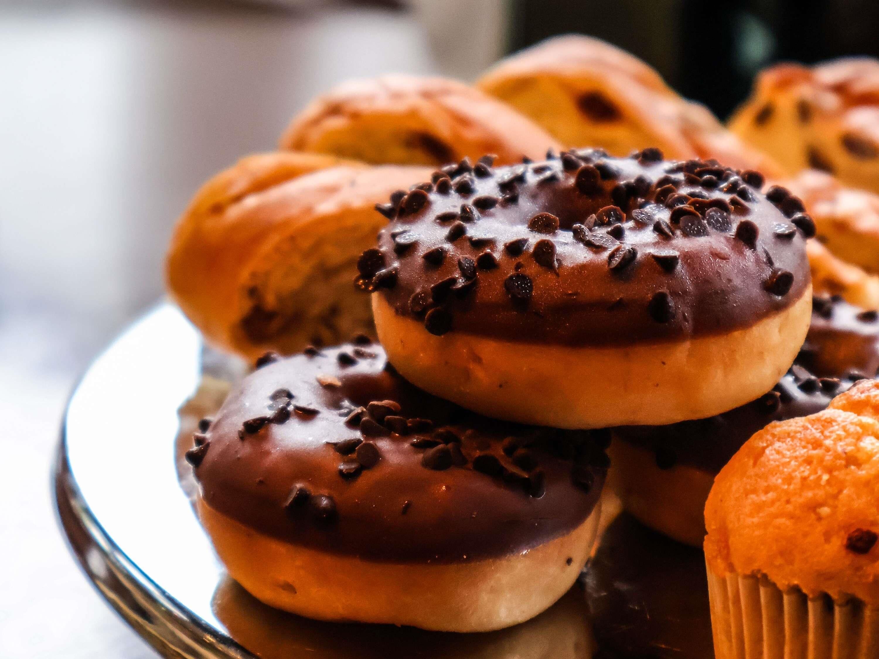 Een bord met chocoladeglazuurde donuts en chocolade chips.