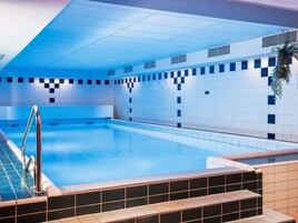 Una piscina techada, sillones reclinables de piscina