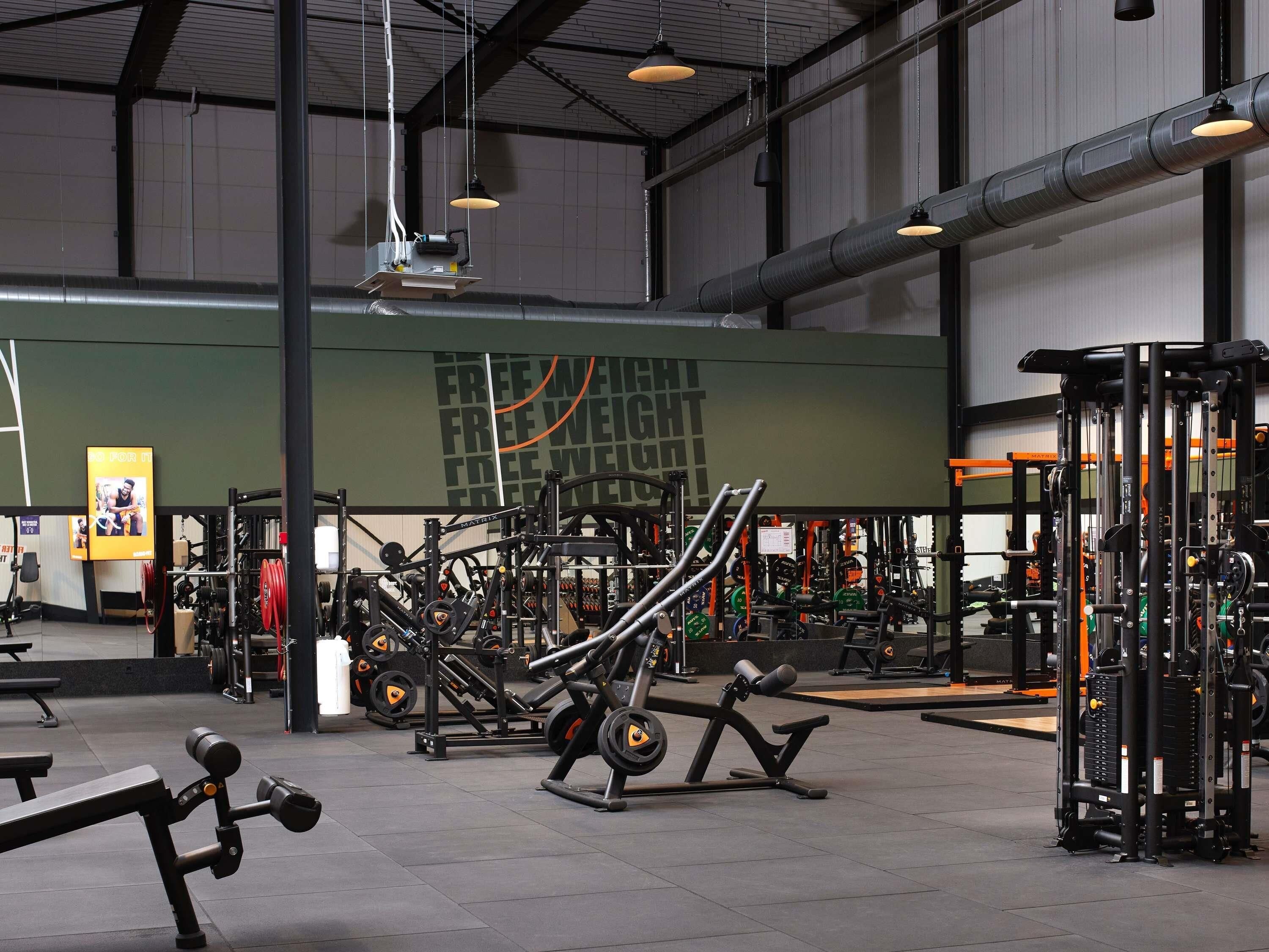 A gym with various exercise equipment, including weight machines and free weights.