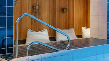 Una piscina techada, sillones reclinables de piscina