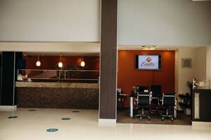 Un área de recepción con mostrador, asientos y un televisor mostrando 'Eventos Catering'.