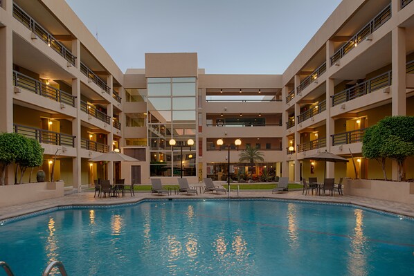 Una piscina al aire libre, sombrillas, tumbonas