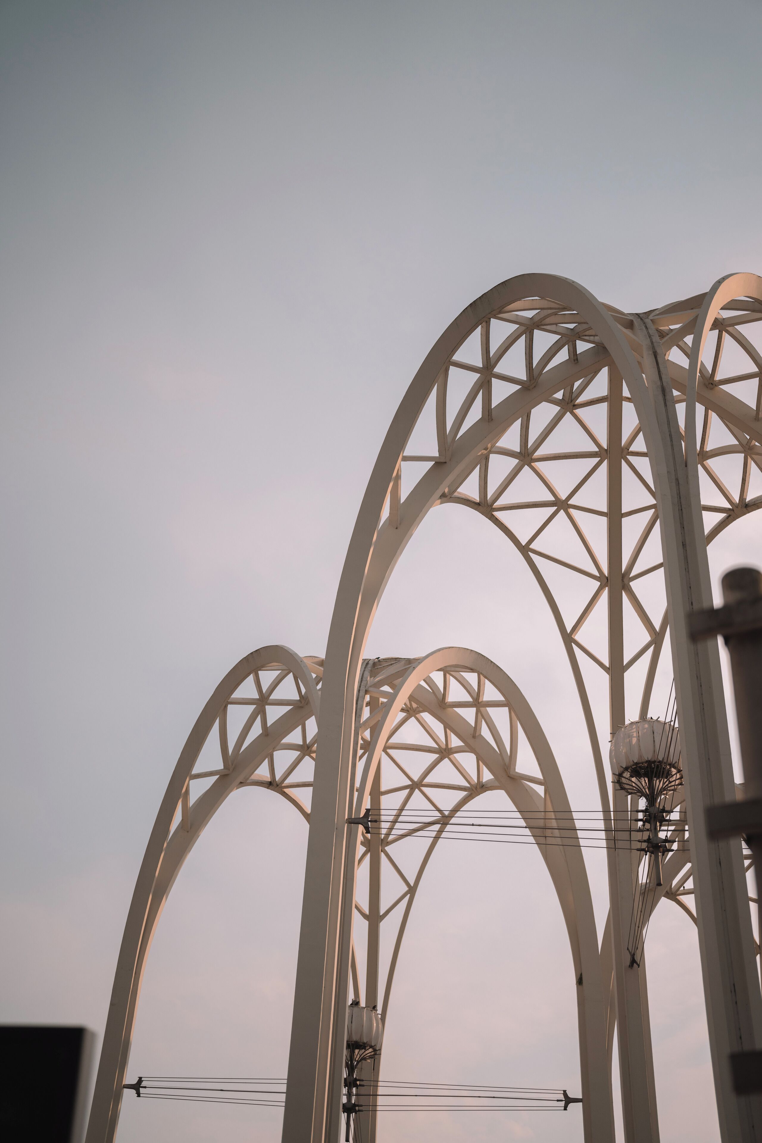 A large, white, arched metal structure, likely part of a bridge or monument.