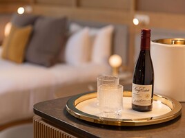 Una bottiglia di Pinot Nero King Estate su un vassoio con un bicchiere, posizionata su un tavolo in una camera d'hotel.