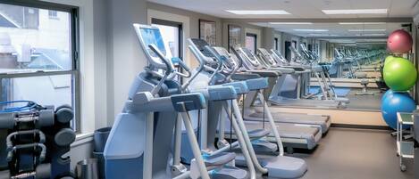 Un gimnasio con cintas de correr, balones de ejercicio y mancuernas.